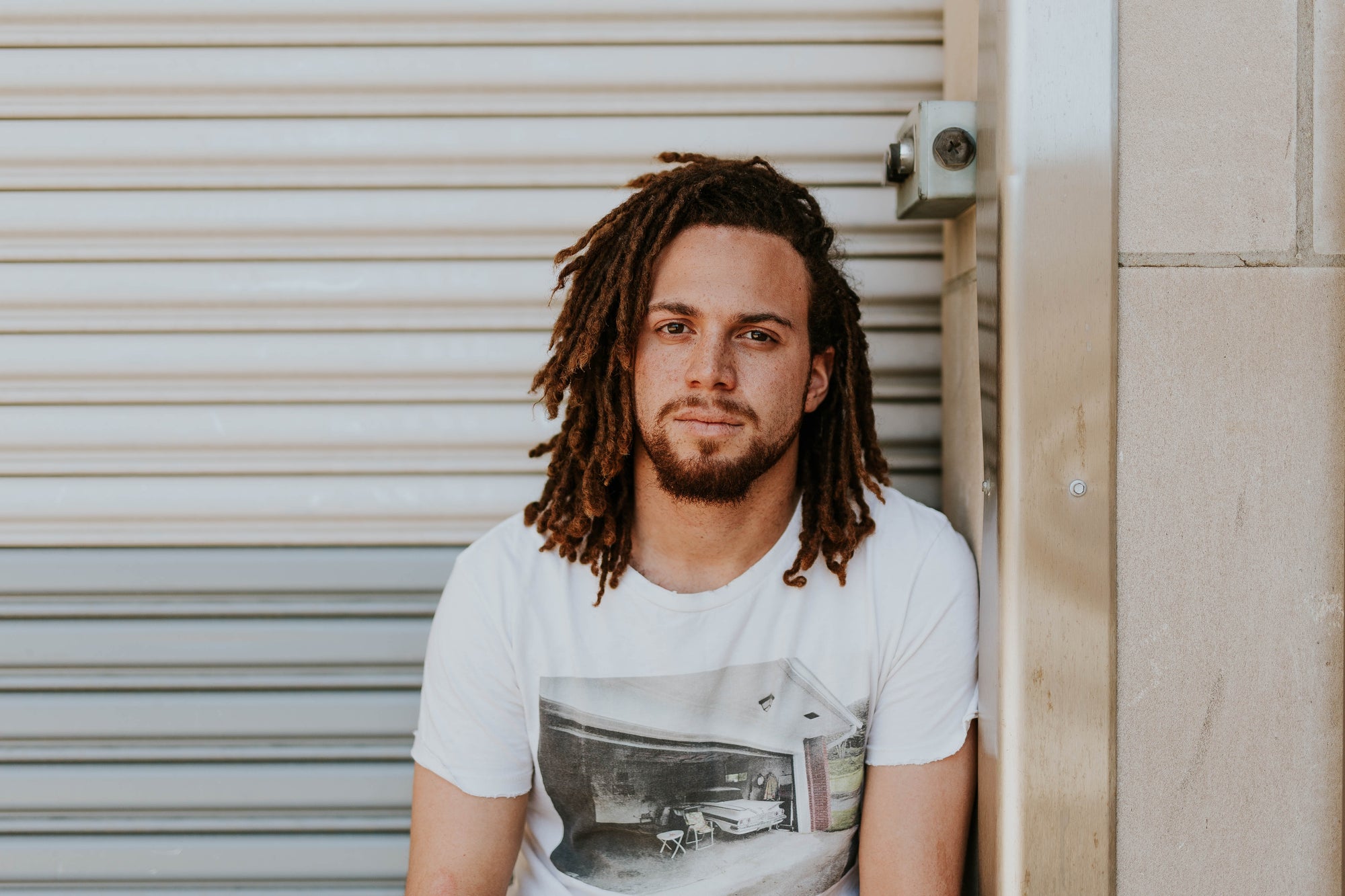 man sitting outside with long hair and beard